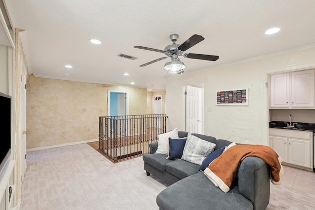 carpeted living room featuring ornamental molding, indoor wet bar, and ceiling fan