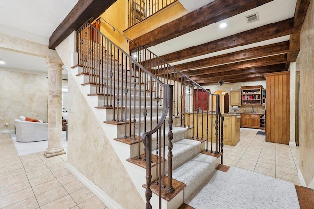 stairs featuring decorative columns, tile patterned flooring, ceiling fan, and beamed ceiling