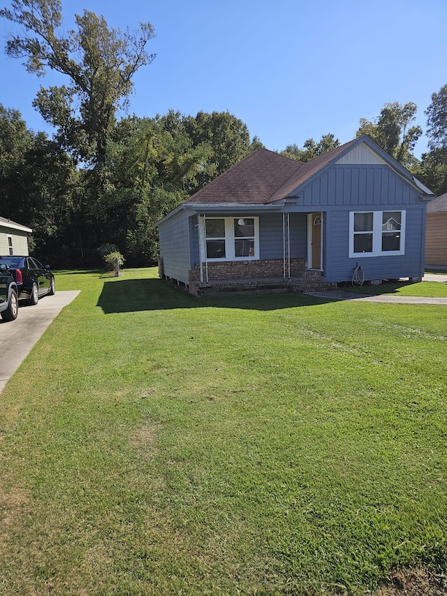 view of front facade with a front yard and board and batten siding