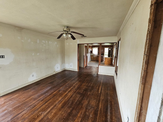 empty room featuring a textured ceiling, wood finished floors, crown molding, a ceiling fan, and baseboards