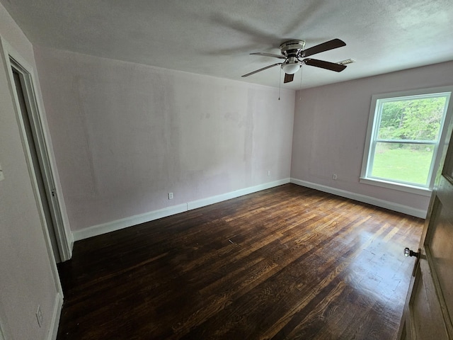 spare room featuring wood finished floors, baseboards, and a ceiling fan