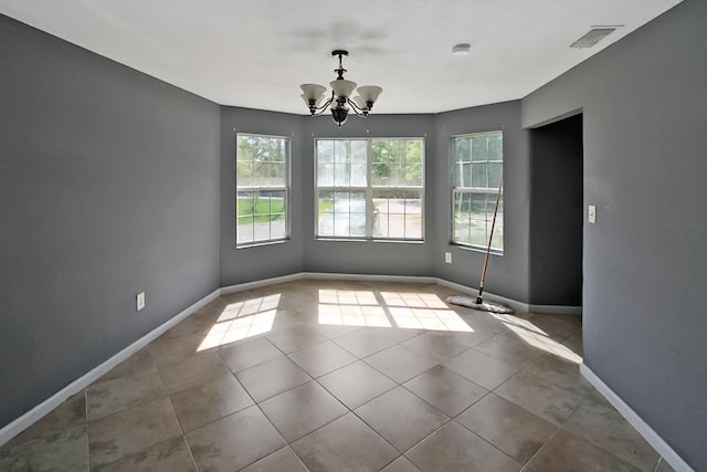 unfurnished dining area with tile patterned floors, a notable chandelier, baseboards, and visible vents