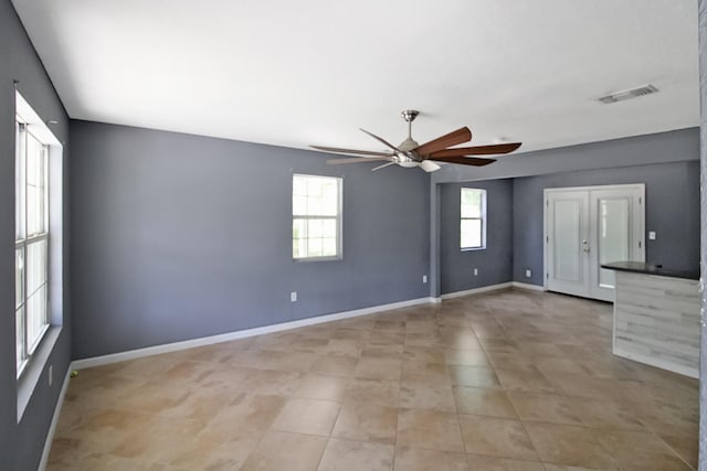 unfurnished bedroom featuring visible vents, baseboards, a ceiling fan, and light tile patterned flooring