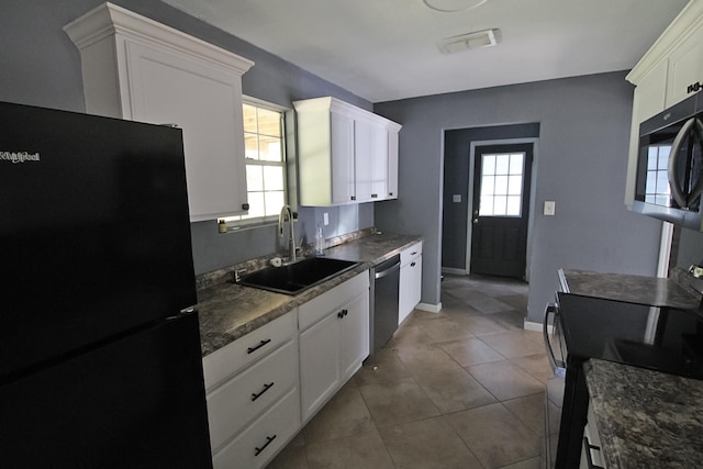 kitchen featuring freestanding refrigerator, stainless steel dishwasher, electric range, white cabinets, and a sink