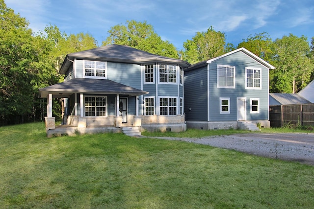 back of house with crawl space, a lawn, and covered porch
