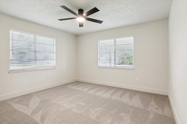 carpeted empty room featuring a textured ceiling and ceiling fan