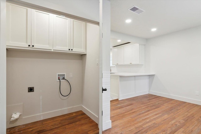 washroom featuring electric dryer hookup, cabinets, light wood-type flooring, and hookup for a washing machine