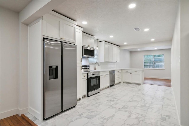 kitchen featuring white cabinets, appliances with stainless steel finishes, a textured ceiling, and sink