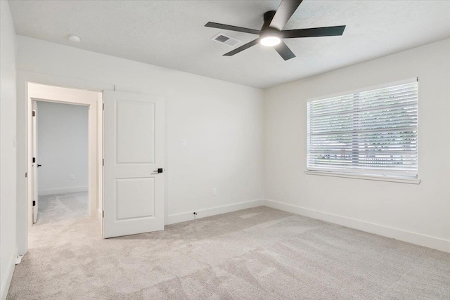 spare room featuring light carpet and ceiling fan