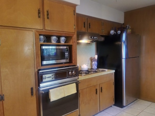 kitchen with light tile patterned floors and stainless steel appliances