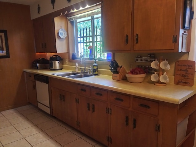 kitchen featuring dishwasher, sink, and light tile patterned flooring