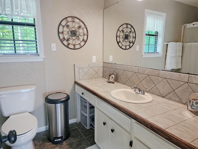 bathroom with toilet, tile patterned floors, decorative backsplash, and plenty of natural light