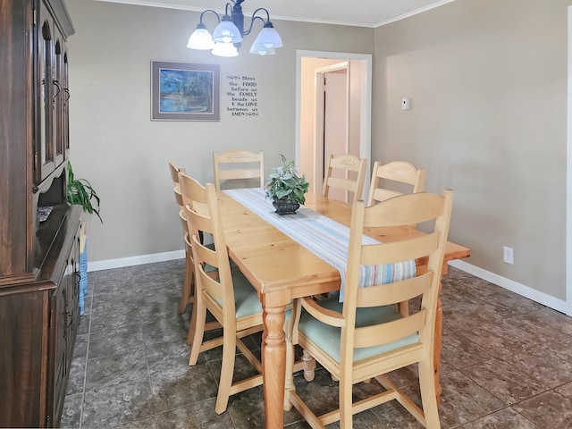 dining space with an inviting chandelier, stone finish floor, baseboards, and ornamental molding