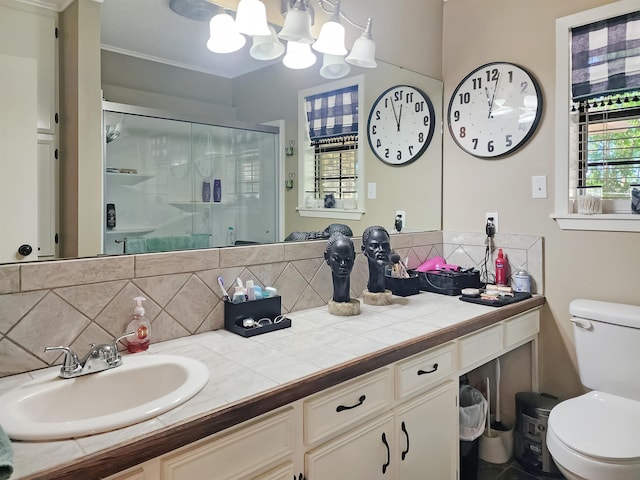 bathroom featuring vanity, a notable chandelier, a stall shower, toilet, and decorative backsplash