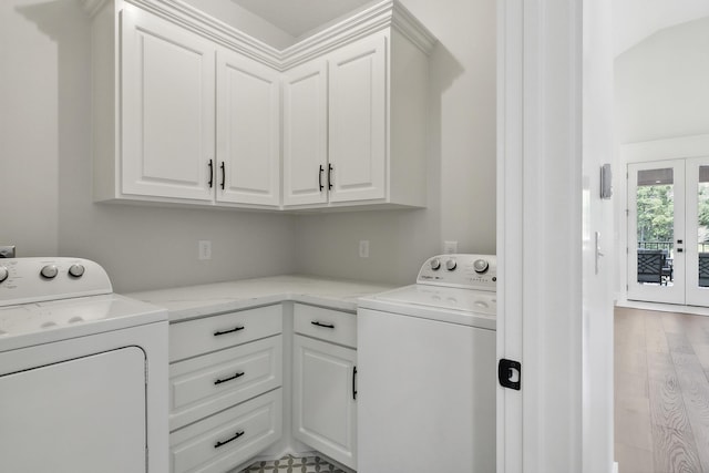 washroom featuring cabinet space, light wood-type flooring, and separate washer and dryer