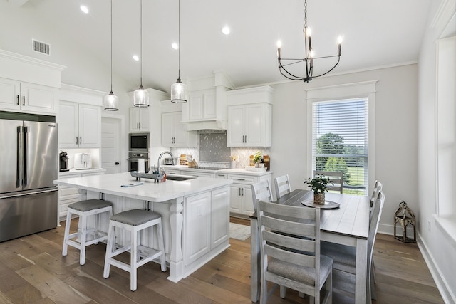 kitchen featuring visible vents, decorative backsplash, an inviting chandelier, stainless steel appliances, and a sink