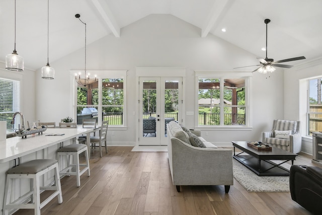 living room with a wealth of natural light, french doors, beam ceiling, and wood finished floors