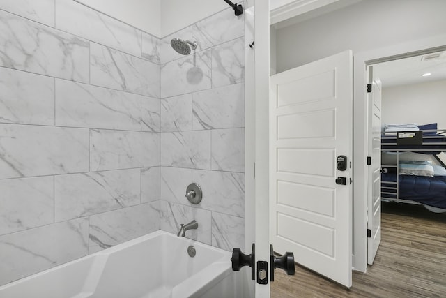 bathroom featuring visible vents, shower / bathing tub combination, and wood finished floors