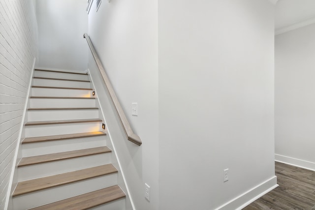 stairway with wood finished floors and baseboards