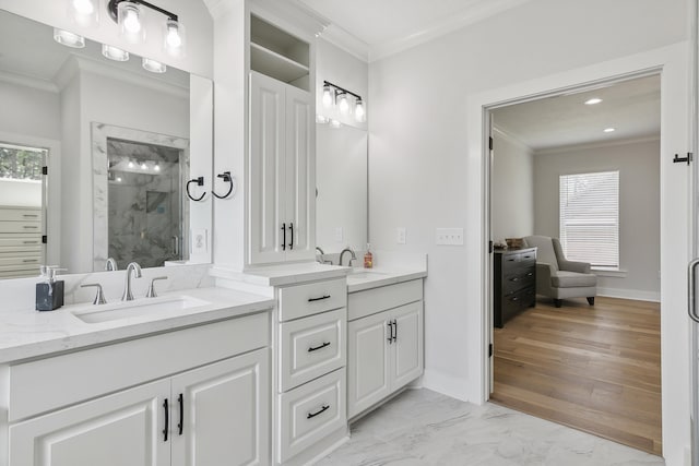 bathroom featuring a sink, a marble finish shower, and crown molding