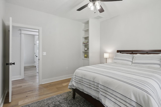 bedroom with visible vents, baseboards, light wood-style flooring, and a ceiling fan