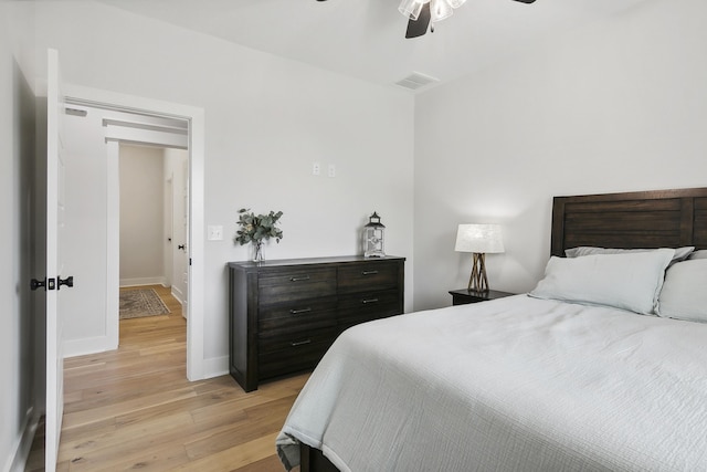 bedroom featuring a ceiling fan, light wood-style flooring, baseboards, and visible vents