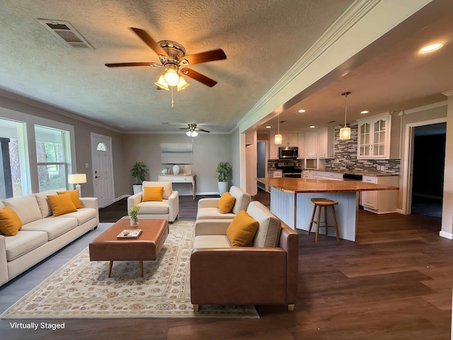 2370 Central Dr, Beaumont, TX 77706 - living room featuring a textured ceiling, crown molding, a ceiling fan, baseboards, and dark wood-style floors