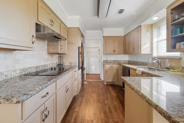 kitchen featuring washer and clothes dryer, black appliances, sink, light stone counters, and wood-type flooring