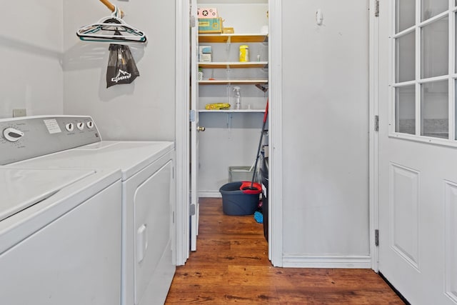 clothes washing area with dark hardwood / wood-style flooring and separate washer and dryer