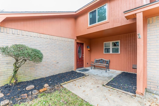 view of exterior entry with a patio area