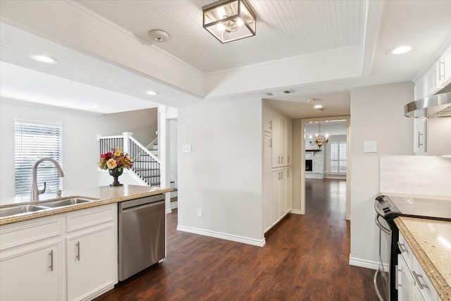 kitchen featuring white cabinets, stainless steel appliances, a tray ceiling, and sink