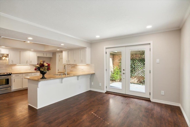 kitchen featuring kitchen peninsula, french doors, sink, white cabinets, and stainless steel stove