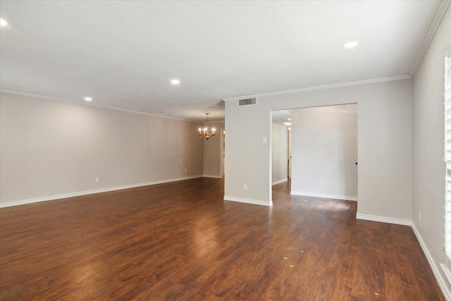 unfurnished room featuring dark hardwood / wood-style floors, crown molding, and a notable chandelier