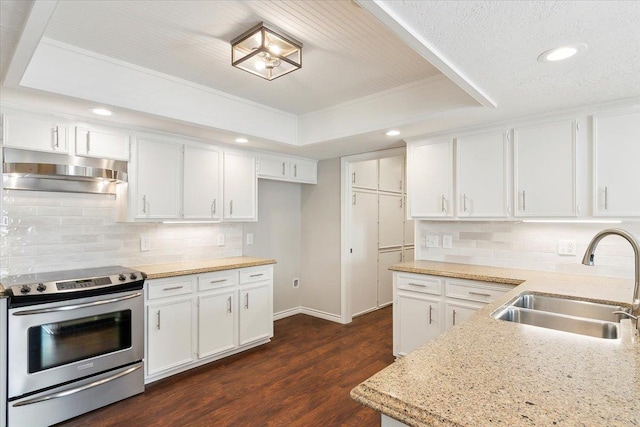 kitchen featuring stainless steel electric stove, a raised ceiling, sink, decorative backsplash, and white cabinetry