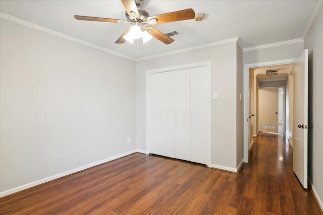 unfurnished bedroom featuring ceiling fan, ornamental molding, dark wood-type flooring, and a closet