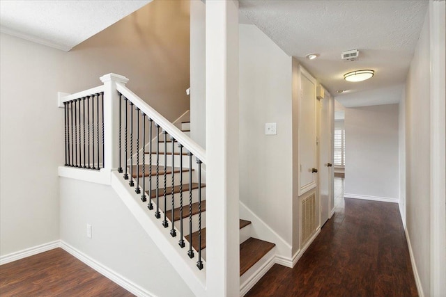 stairs featuring hardwood / wood-style floors and a textured ceiling