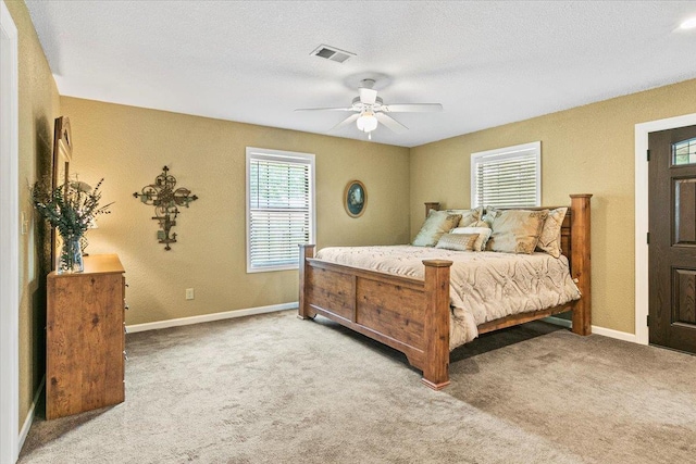 carpeted bedroom featuring a textured ceiling and ceiling fan