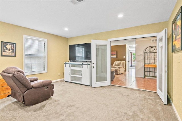 living area with french doors and light colored carpet