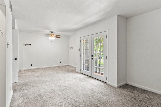 carpeted spare room featuring ceiling fan, a textured ceiling, and french doors