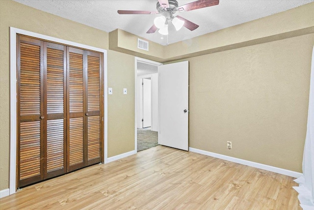 unfurnished bedroom featuring light wood-type flooring, a closet, and ceiling fan