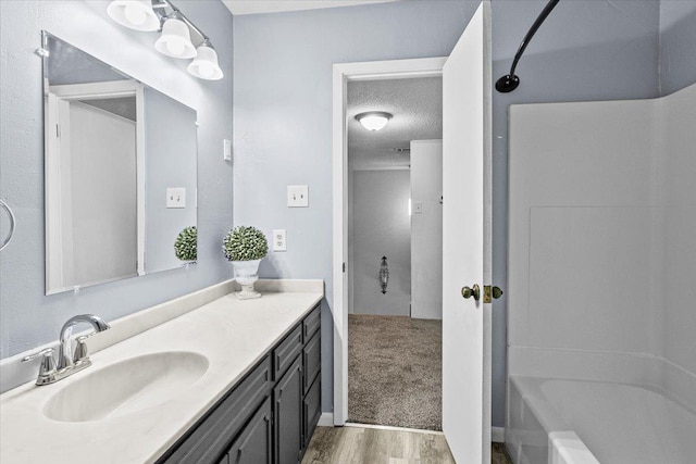 bathroom with vanity, tub / shower combination, wood-type flooring, and a textured ceiling