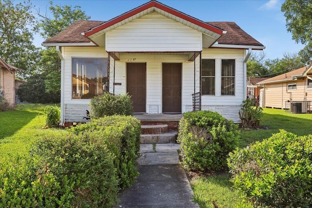 1710 17th St, Port Arthur, TX 77640 - bungalow-style house with central air condition unit, a shingled roof, and a front yard