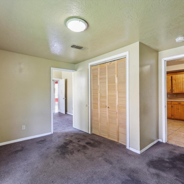 1710 17th St, Port Arthur, TX 77640 - unfurnished bedroom with visible vents, a textured ceiling, carpet floors, and a closet