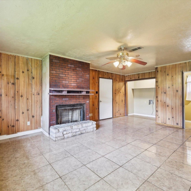 1710 17th St, Port Arthur, TX 77640 - unfurnished living room with wooden walls, baseboards, ceiling fan, and a textured ceiling