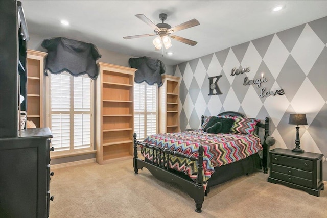 bedroom featuring ceiling fan, light colored carpet, and multiple windows