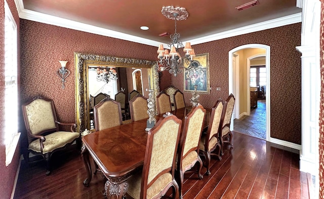 dining area featuring a chandelier, dark wood-type flooring, and ornamental molding