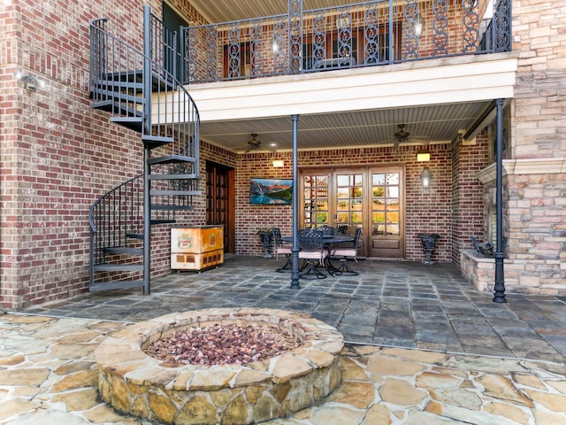 view of patio with french doors, a balcony, an outdoor fire pit, and ceiling fan