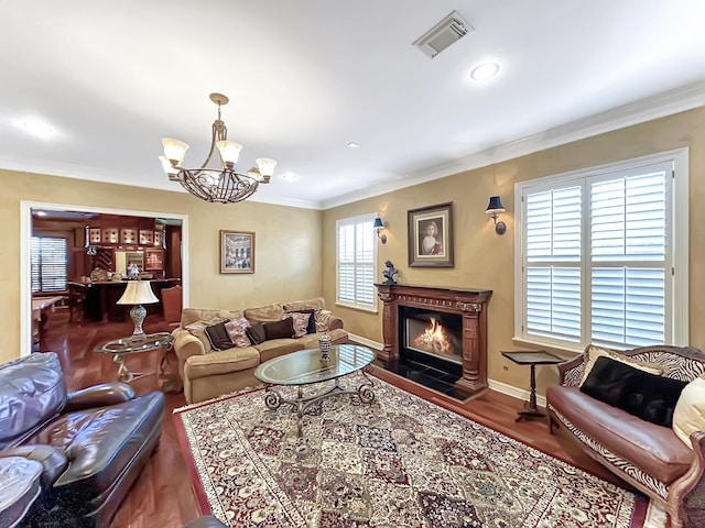 living room featuring ornamental molding, wood-type flooring, and a notable chandelier