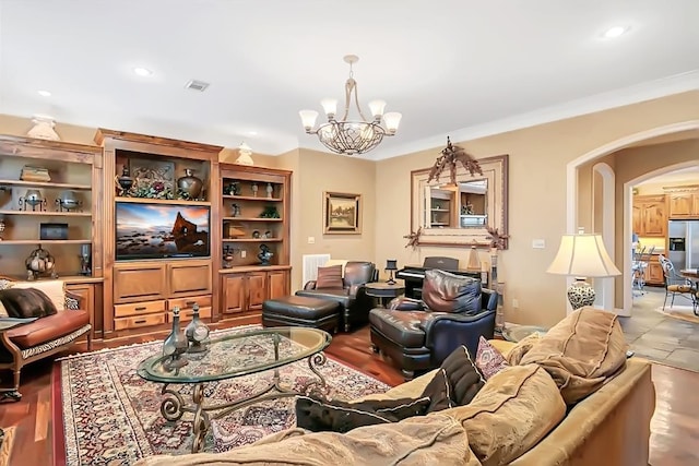 living room with crown molding and a chandelier