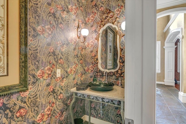 bathroom with decorative columns and ornamental molding